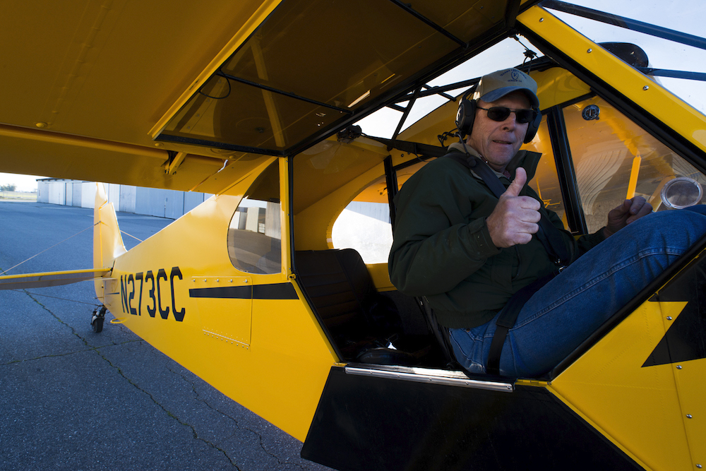 pilot in rice seeding plane giving thumbs up