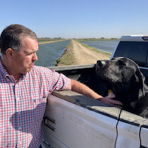 man and his dog in truck bed